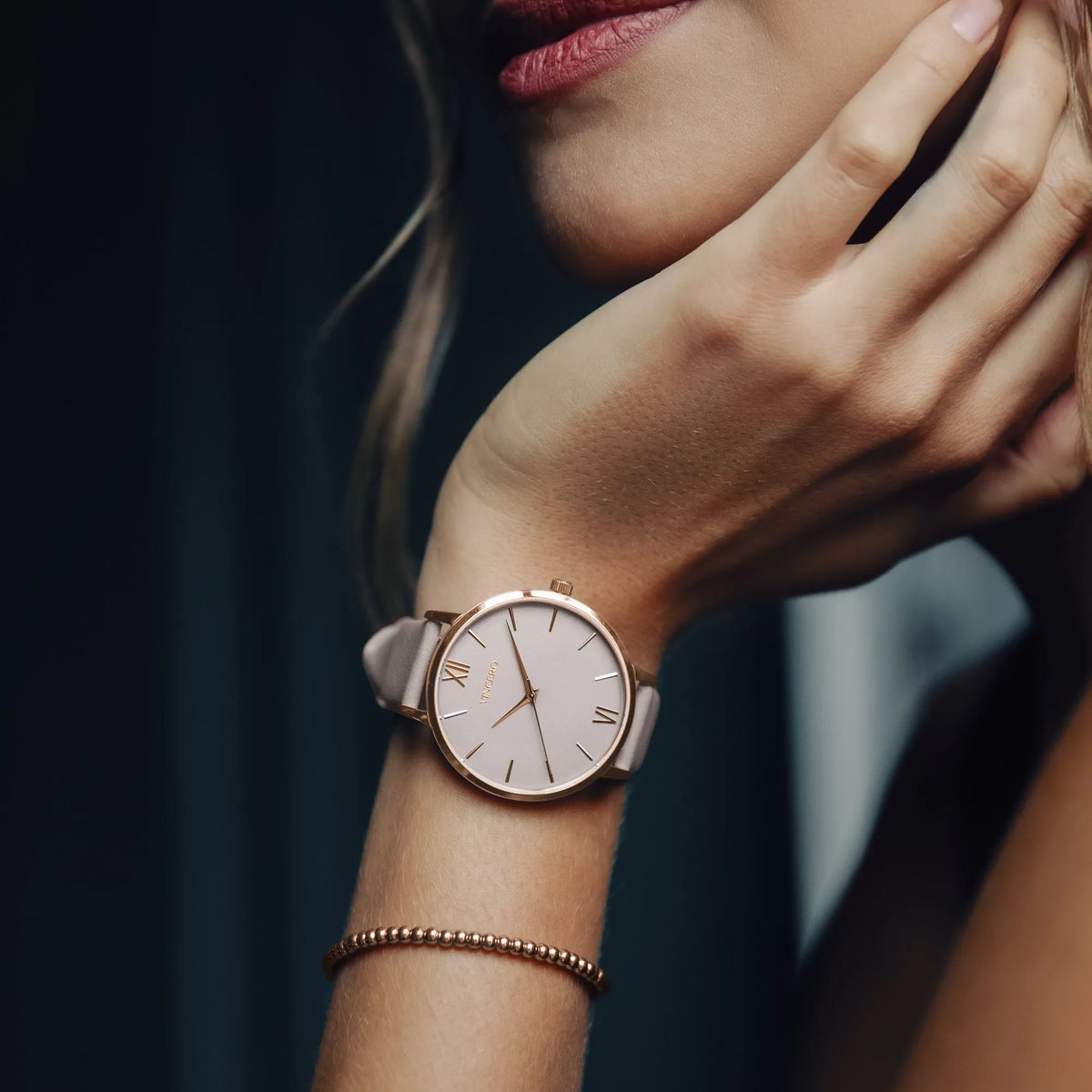 Rose gold watch on a wrist with a blurred background