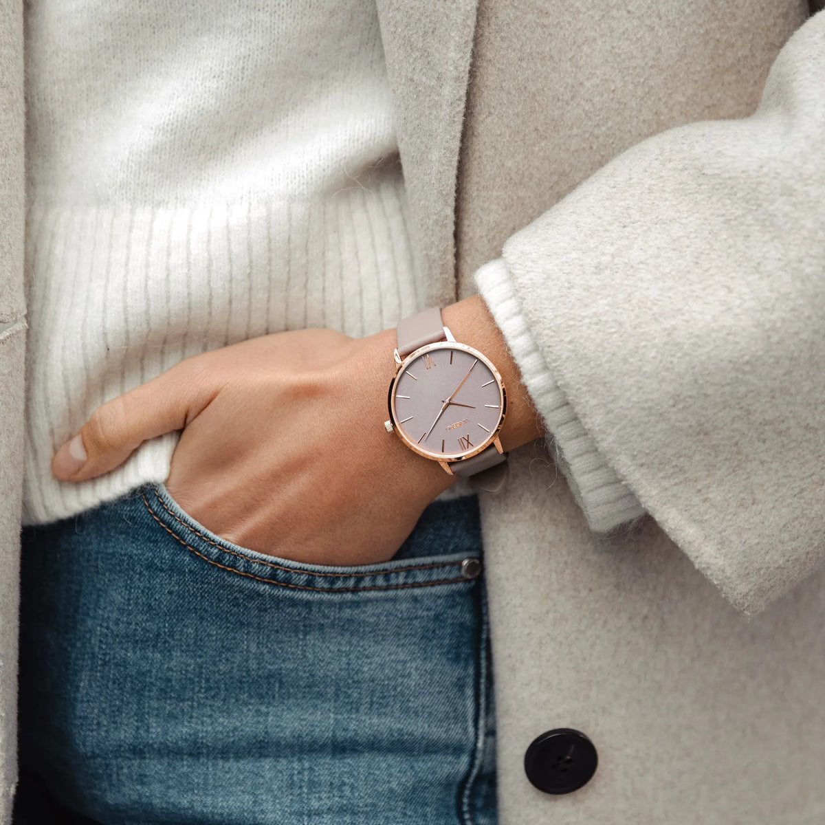 Person wearing a watch with a neutral background