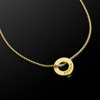 A gold chain necklace featuring a circular ring pendant with the name 'SOPHIA' engraved on its side, displayed on a reflective black background.