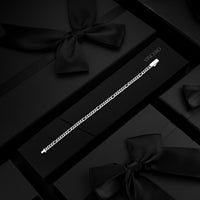 A silver-toned chain bracelet displayed on a black gift box with a black ribbon bow, surrounded by matching black boxes. The brand name VINCI GO is printed on the box.