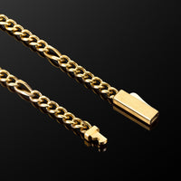A close-up of a gold-toned metal chain necklace with a rectangular pendant and a small cross charm, photographed on a glossy black reflective surface.