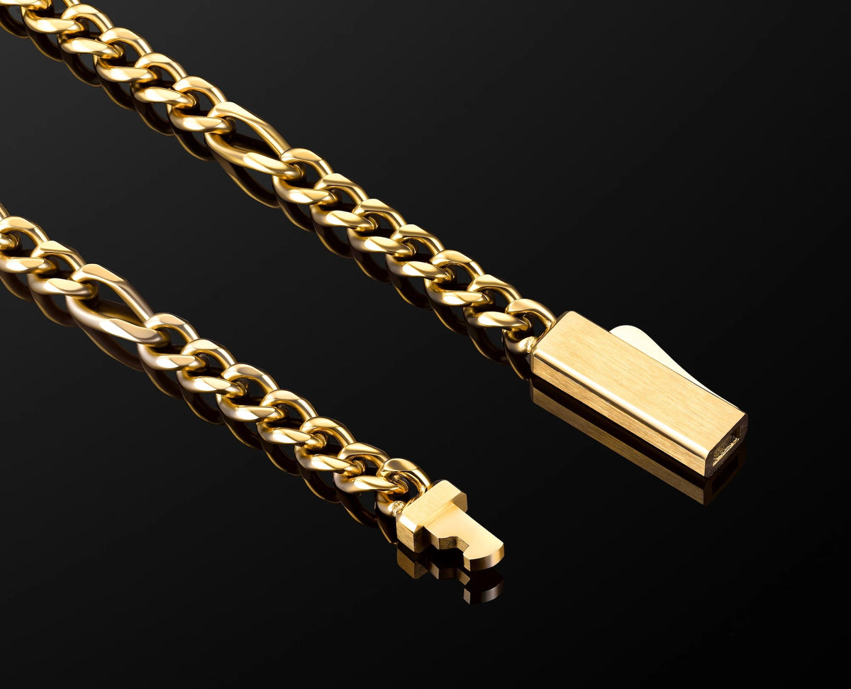 A close-up of a gold-toned figaro chain necklace , photographed on a glossy black background.