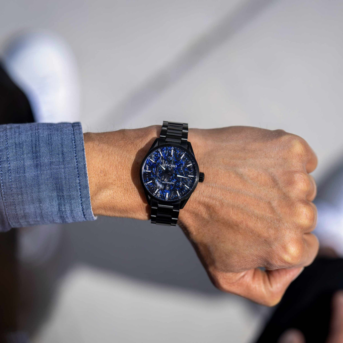 Man wearing blue Carbon men's watch on wrist. 