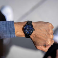 Man wearing blue Carbon men's watch on wrist. 
