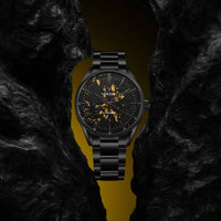 Black wristwatch with gold accents on a dark textured background