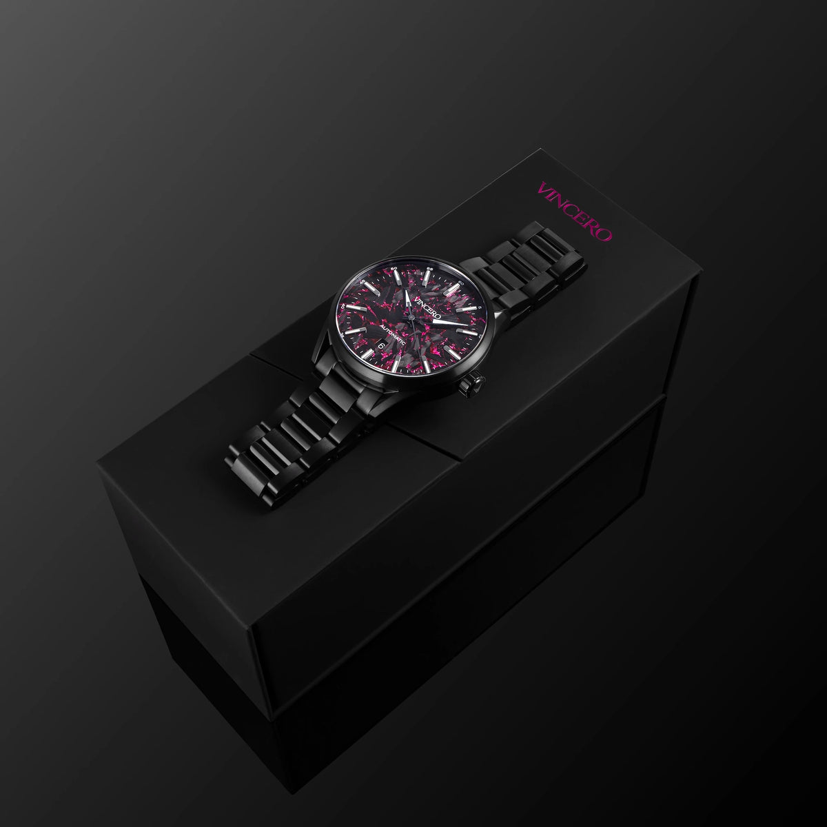 Black watch with red accents on a black box against a dark background