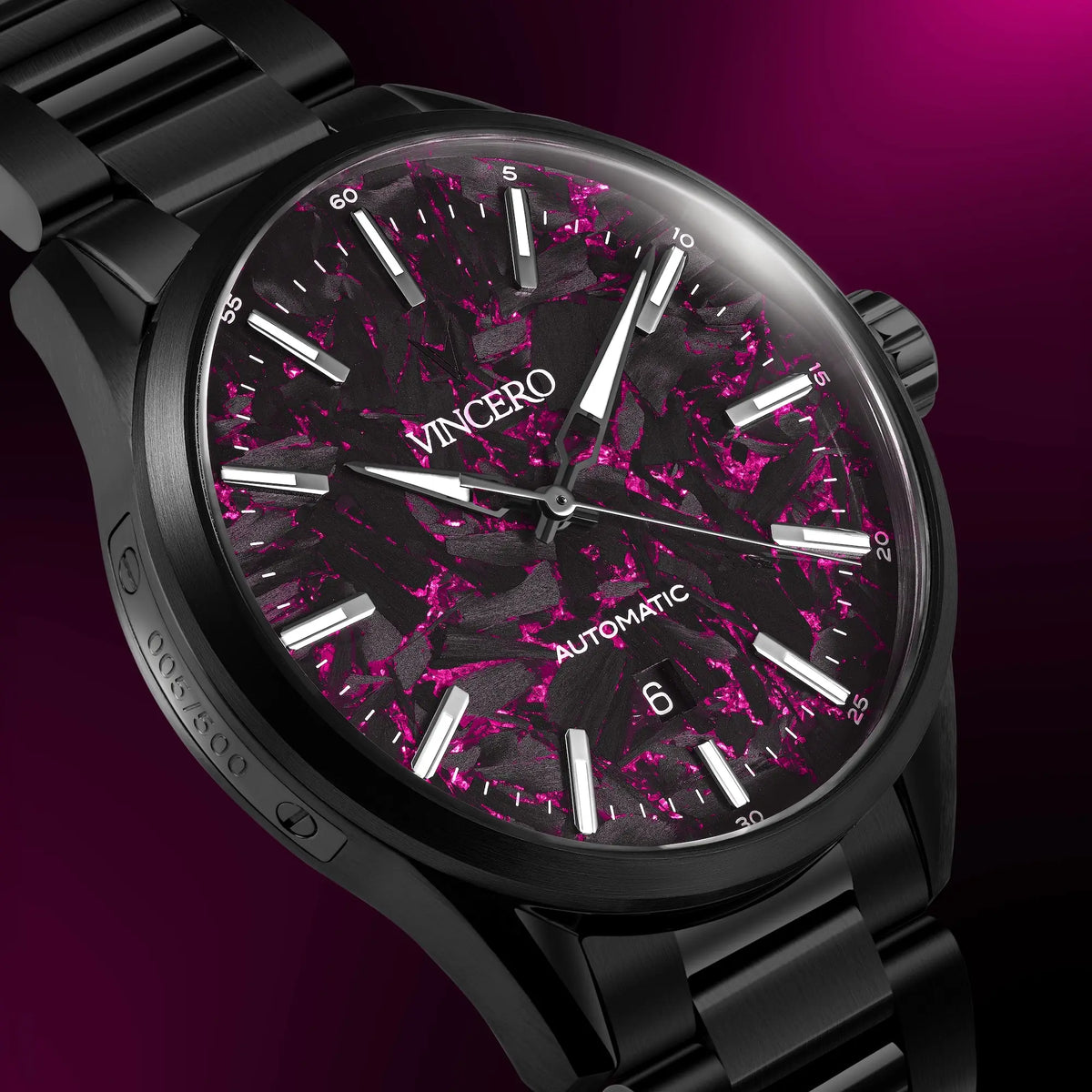 Black wristwatch with a pink and black speckled face on a purple background