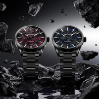 Two black wrist watches with detailed faces on a rocky surface with a moon and stars background.