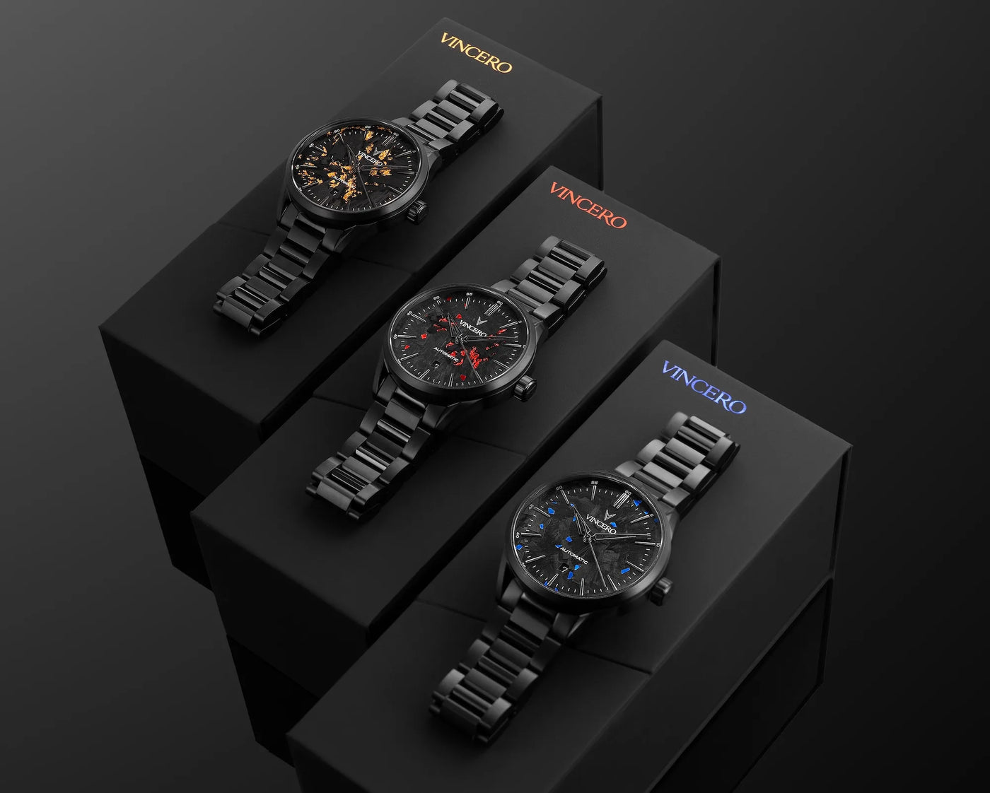 Three black wristwatches on Vincero branded boxes against a dark background
