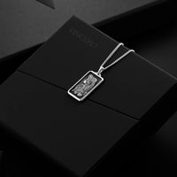 Silver necklace with a pendant on a black surface, featuring the brand 'Vinceiro'.