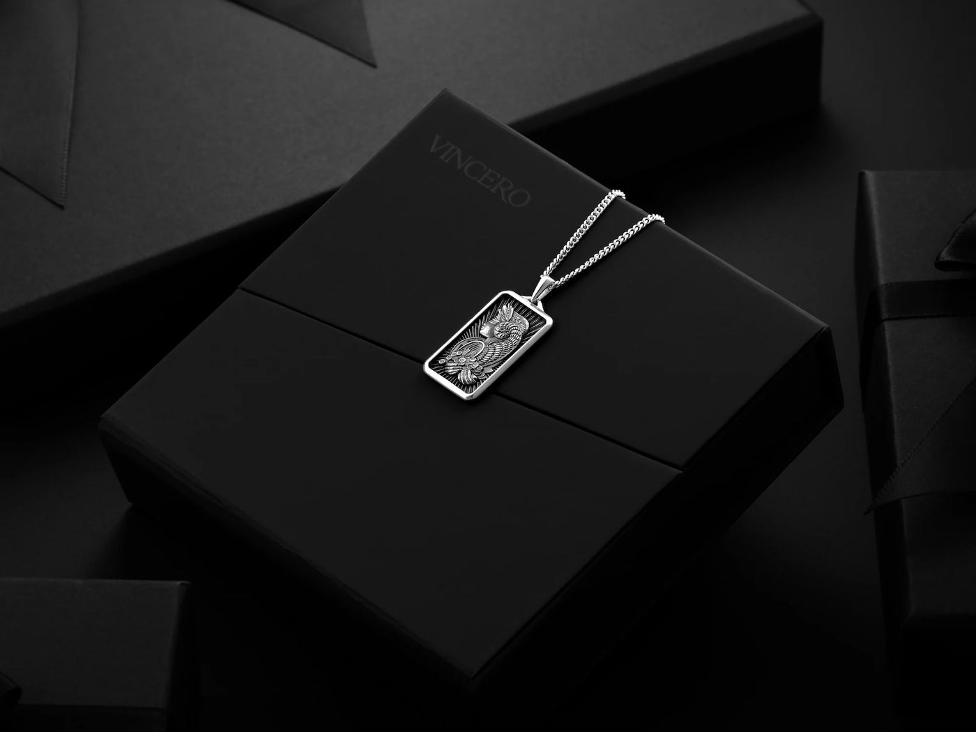 Silver pendant on a black box with 'Vincero' branding