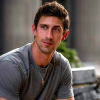 Man wearing a gray shirt with a blurred background