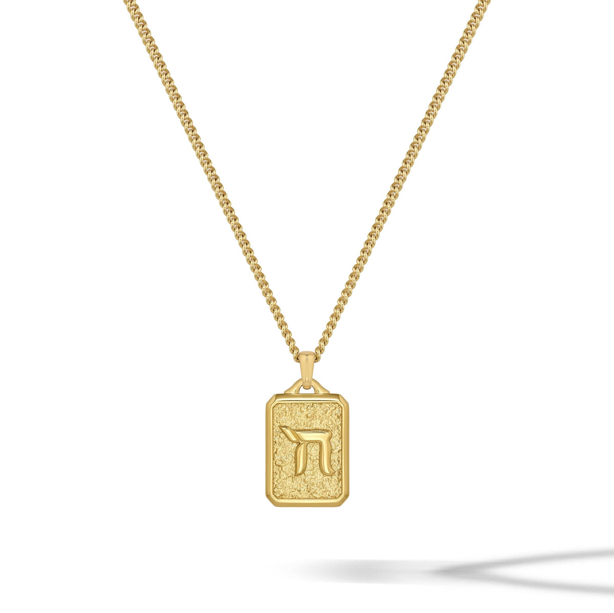 Gold necklace with a rectangular pendant on a white background