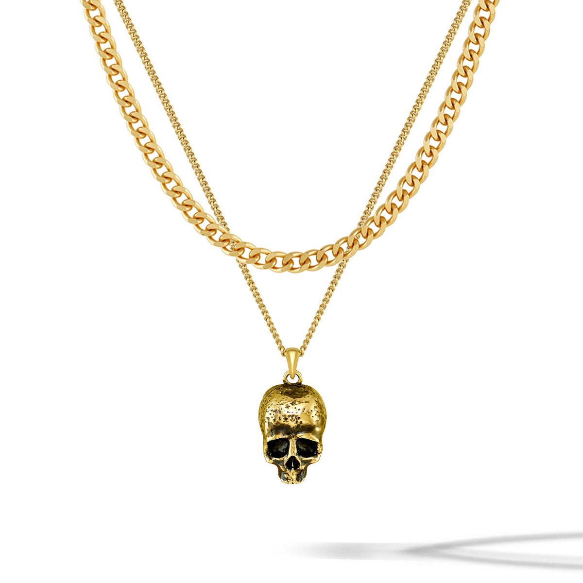 Gold chain necklace with a skull pendant on a white background