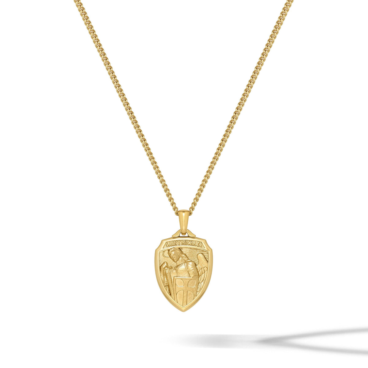Gold necklace with a shield-shaped pendant on a white background
