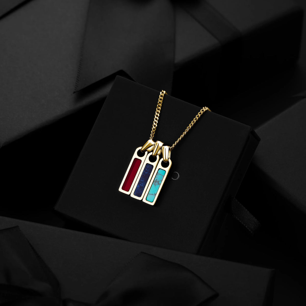 Gold necklace with colorful pendant on a black background