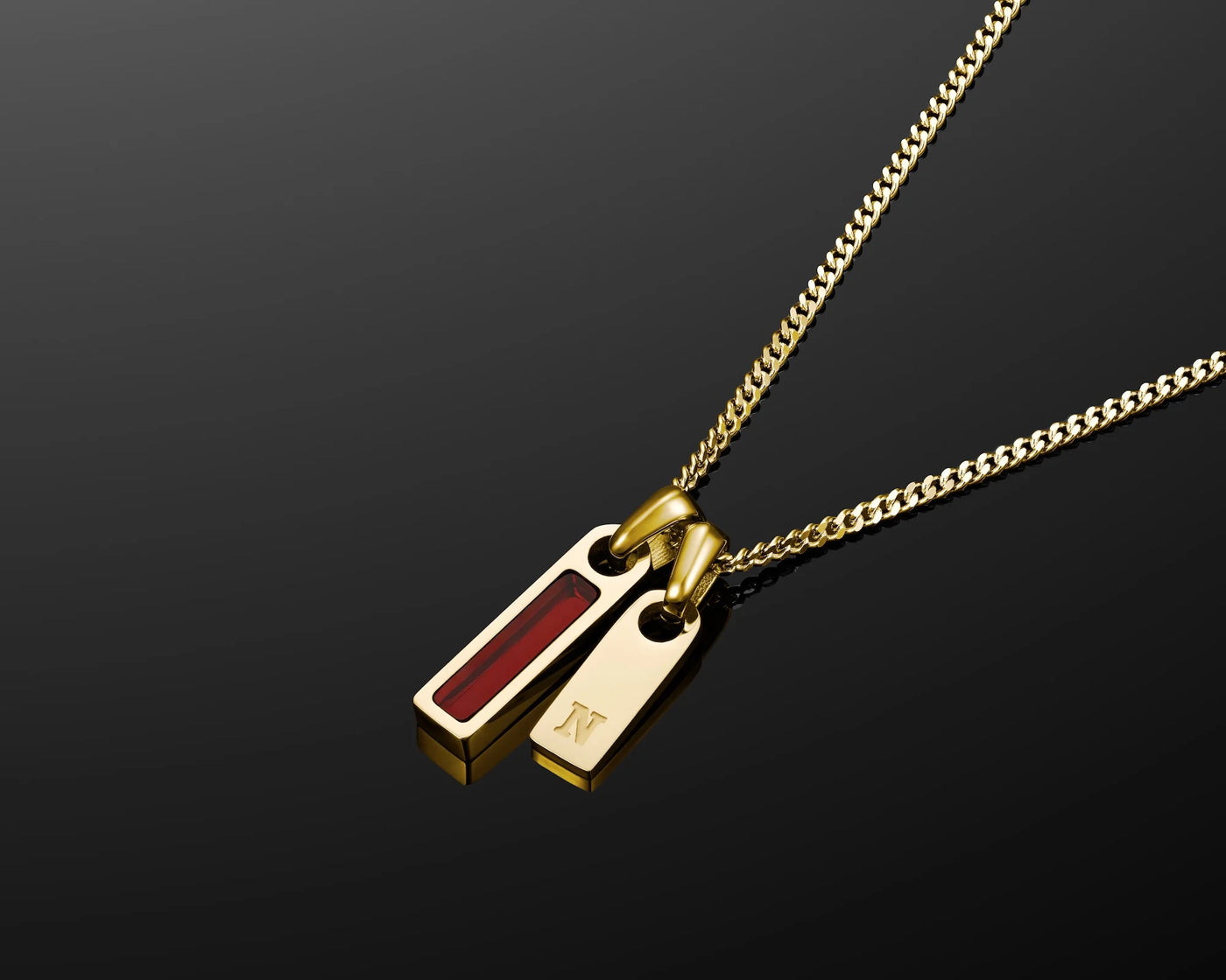 Gold necklace with a red pendant on a black background