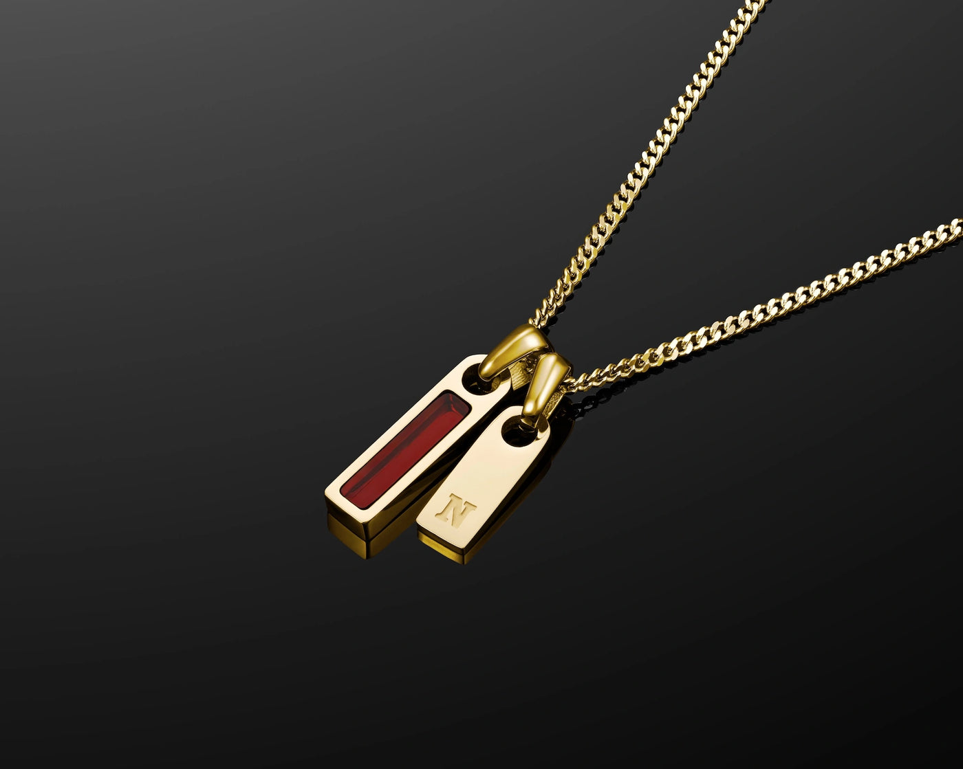 Gold necklace with a red pendant on a black background