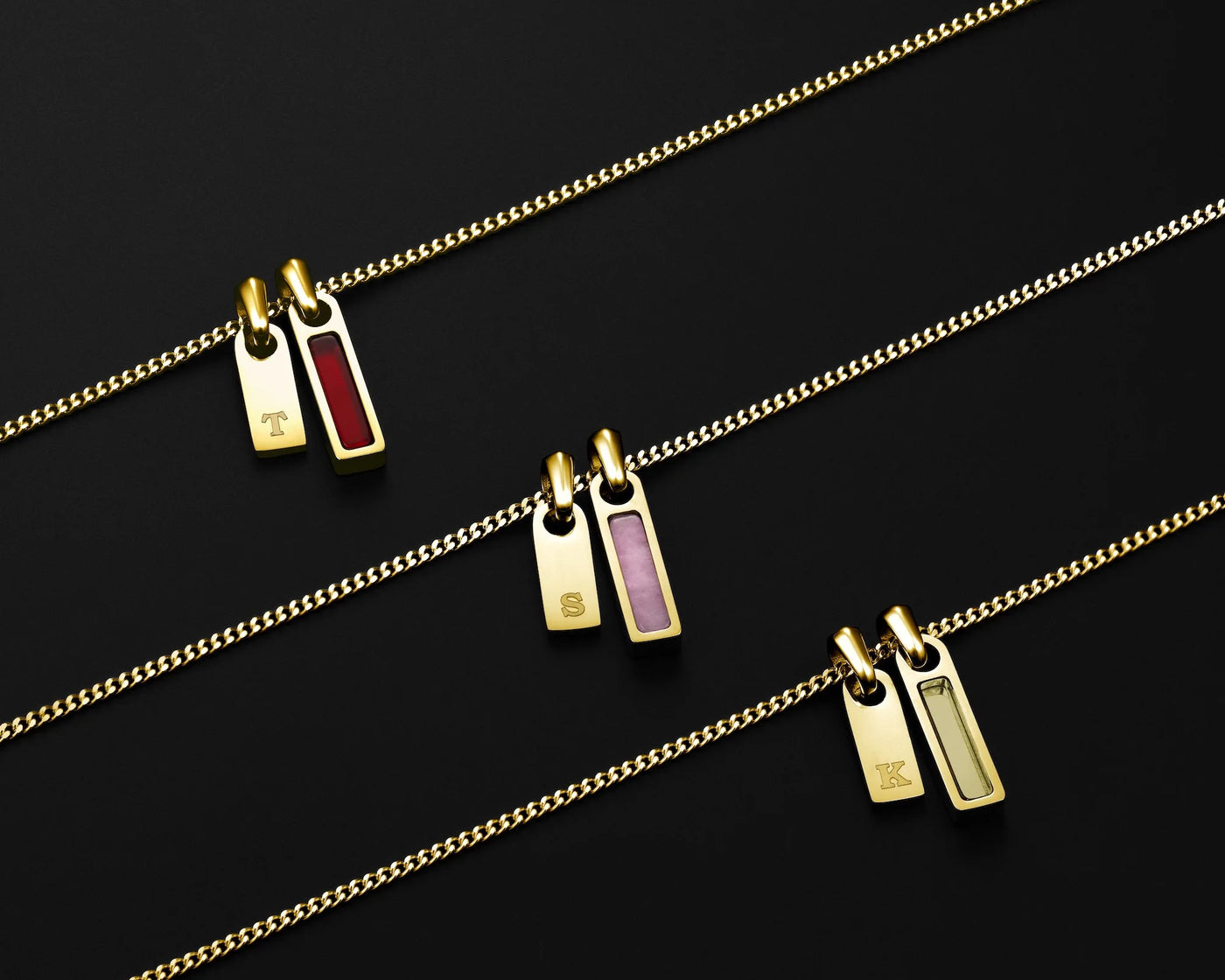 Gold necklaces with pendant tags on a black background