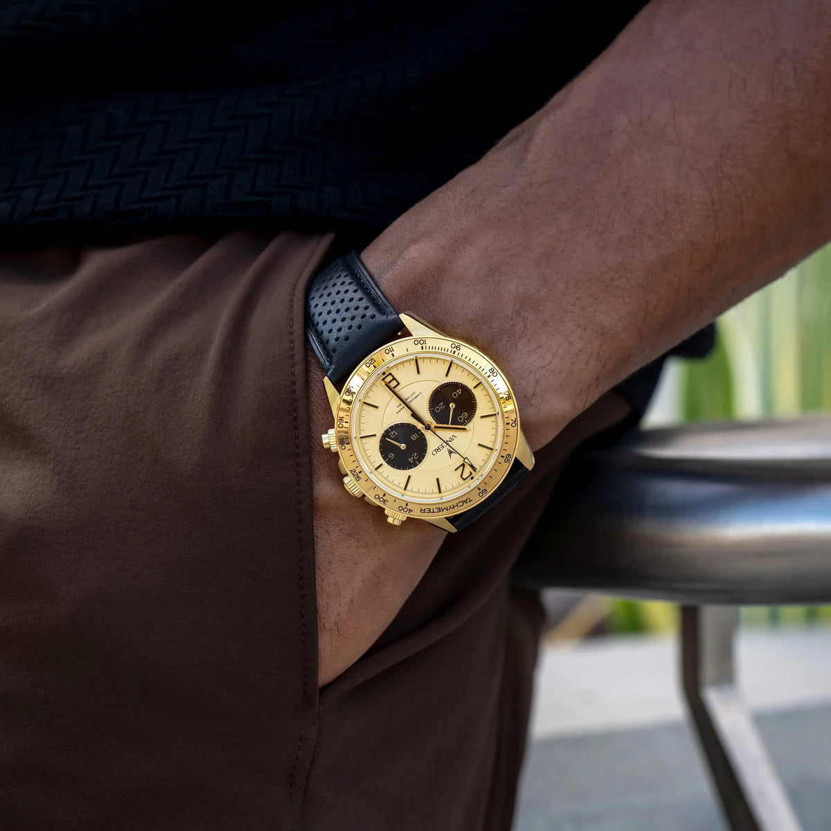 Gold wristwatch on a person's wrist with a blurred background