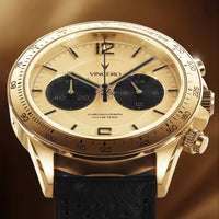 Gold wristwatch with black strap on a brown background