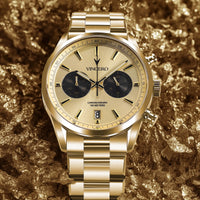 Gold wristwatch with a detailed face on a textured gold background
