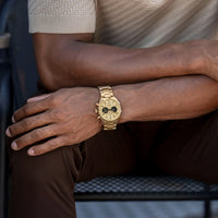 Gold wristwatch on a person's wrist with a blurred background