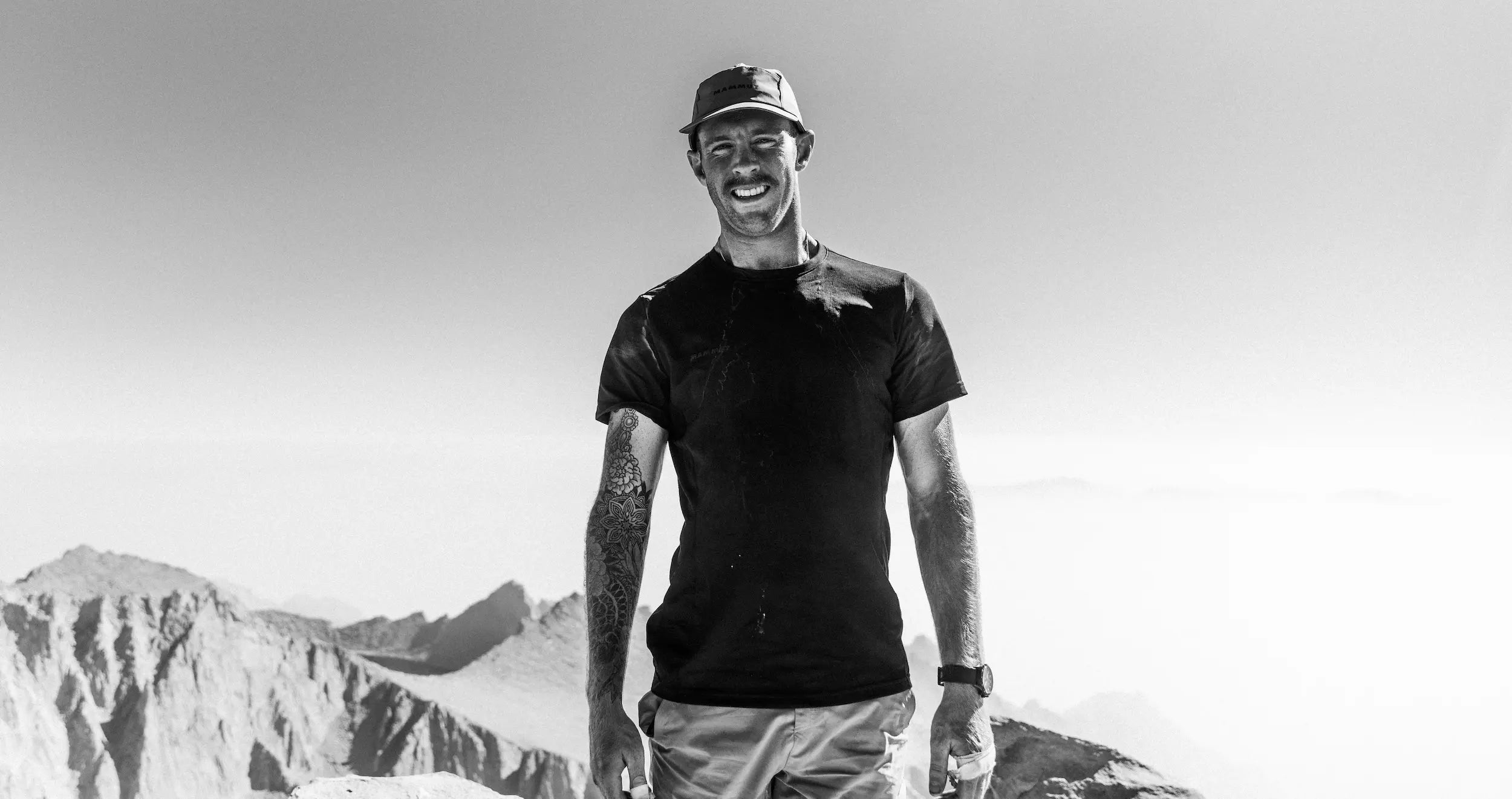 Male hiker standing with mountains in the background