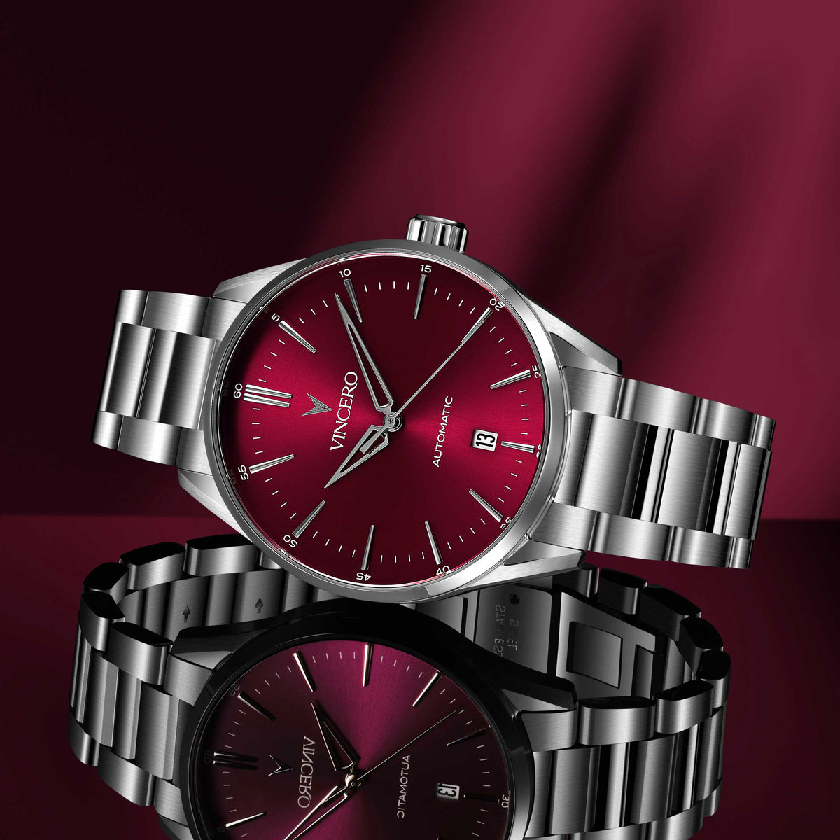 Silver wristwatch with a red face on a dark red background