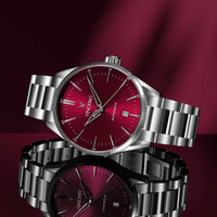 Silver wristwatch with a red face on a dark red background