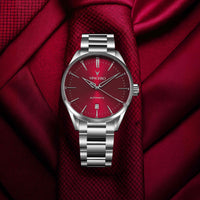 Silver watch with a red face on a red fabric background