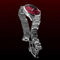 Silver watch with a red face on a dark background