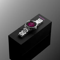 Silver watch with a dark face on a black stand against a gray background