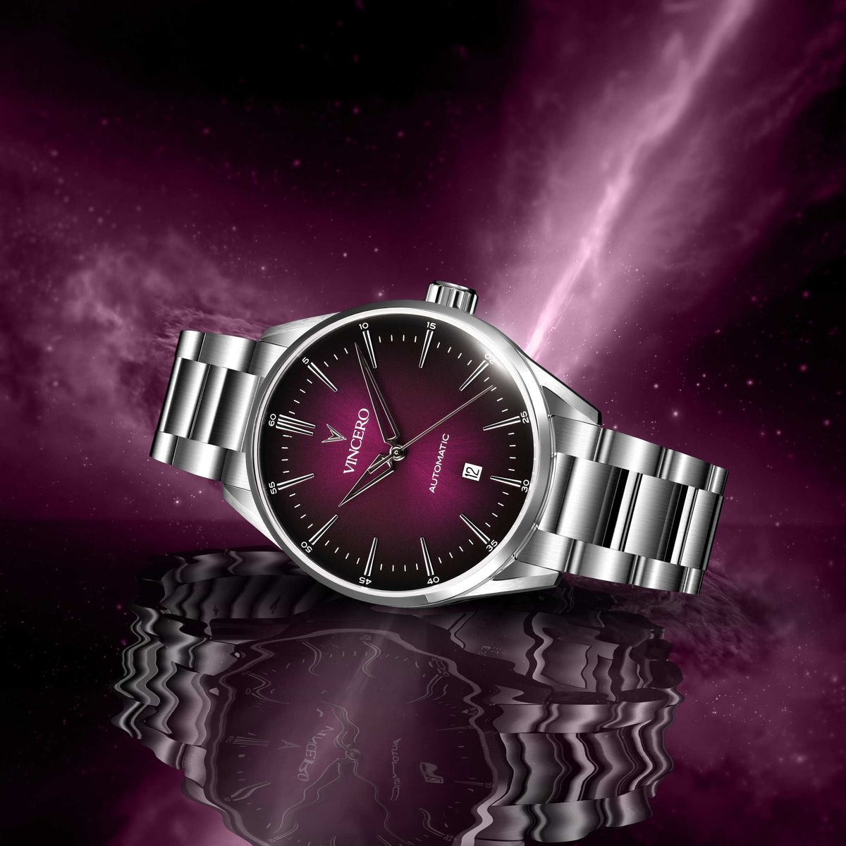 Silver watch with a dark face on a reflective surface against a purple cosmic background