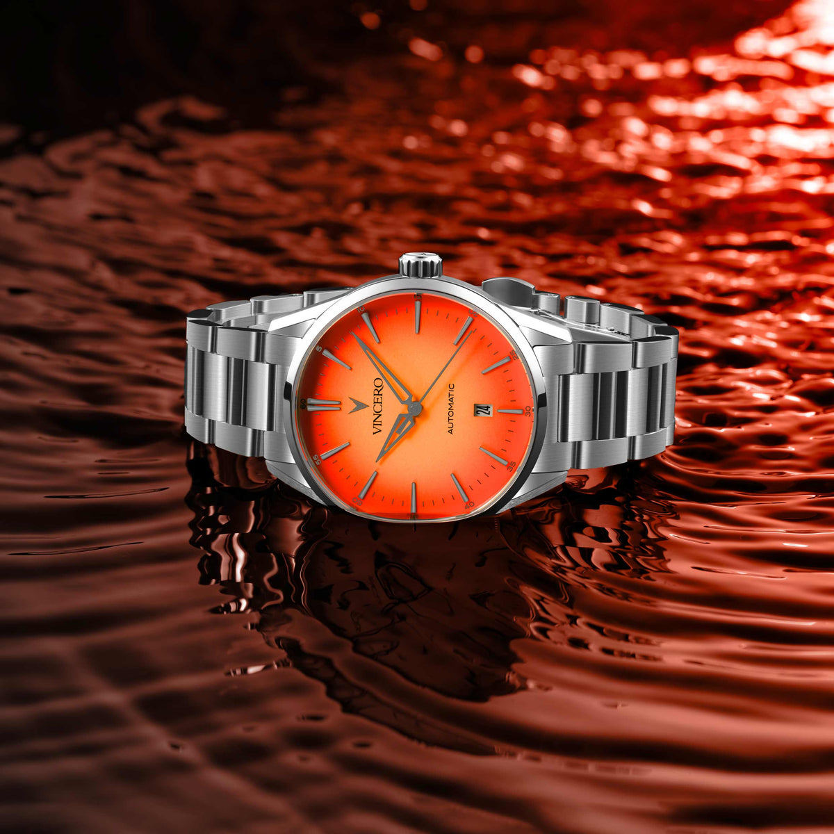 Solar Flare Edition watch, featuring a orange face, stainless steel casing, and steel band, displayed in a puddle of water.