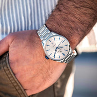 Silver watch on a wrist with a blurred background