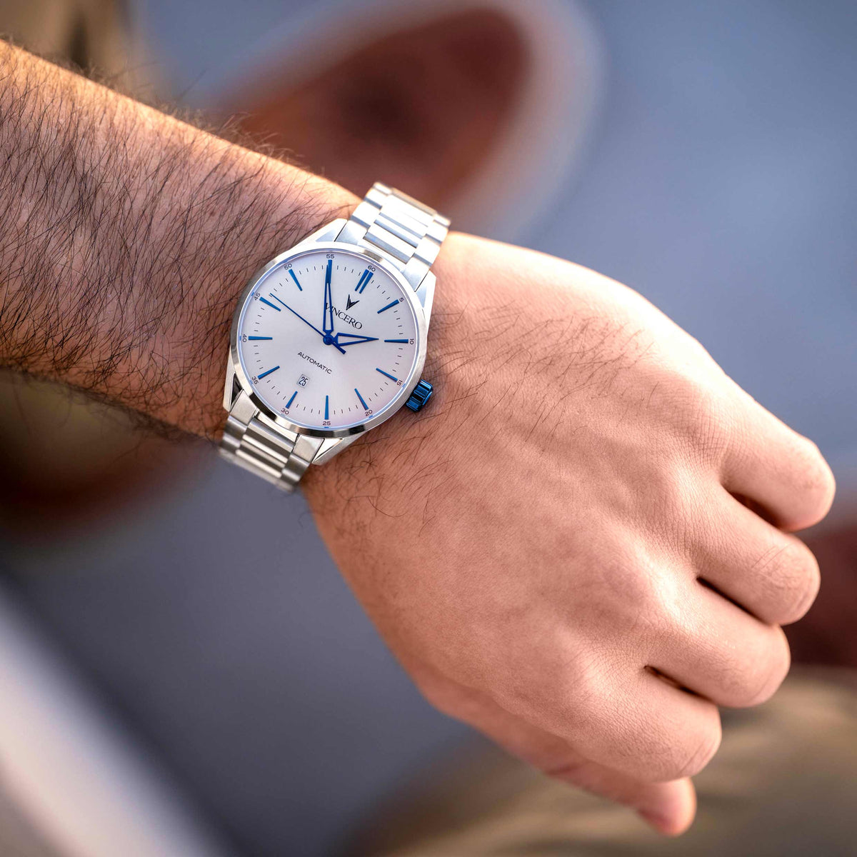 Silver watch on a person's wrist with a blurred background