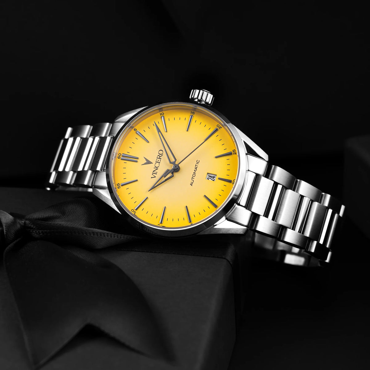 Silver watch with a yellow face on a black background
