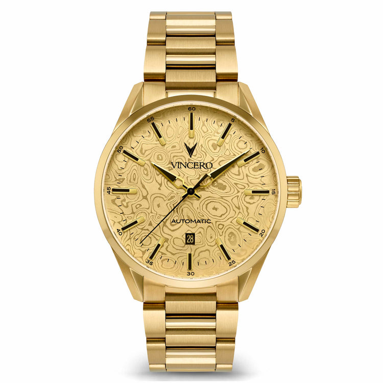 A gold-tone stainless steel wristwatch with a matching gold-tone link bracelet, featuring a textured, patterned dial and a date window at 3 o'clock, shown against a plain white background.