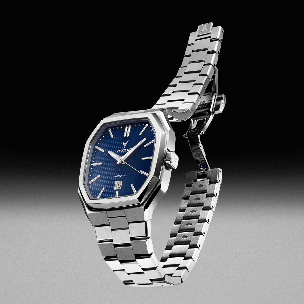 Silver watch with blue face on a gray background