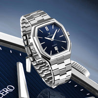 Silver watch with blue dial on a blue gradient background