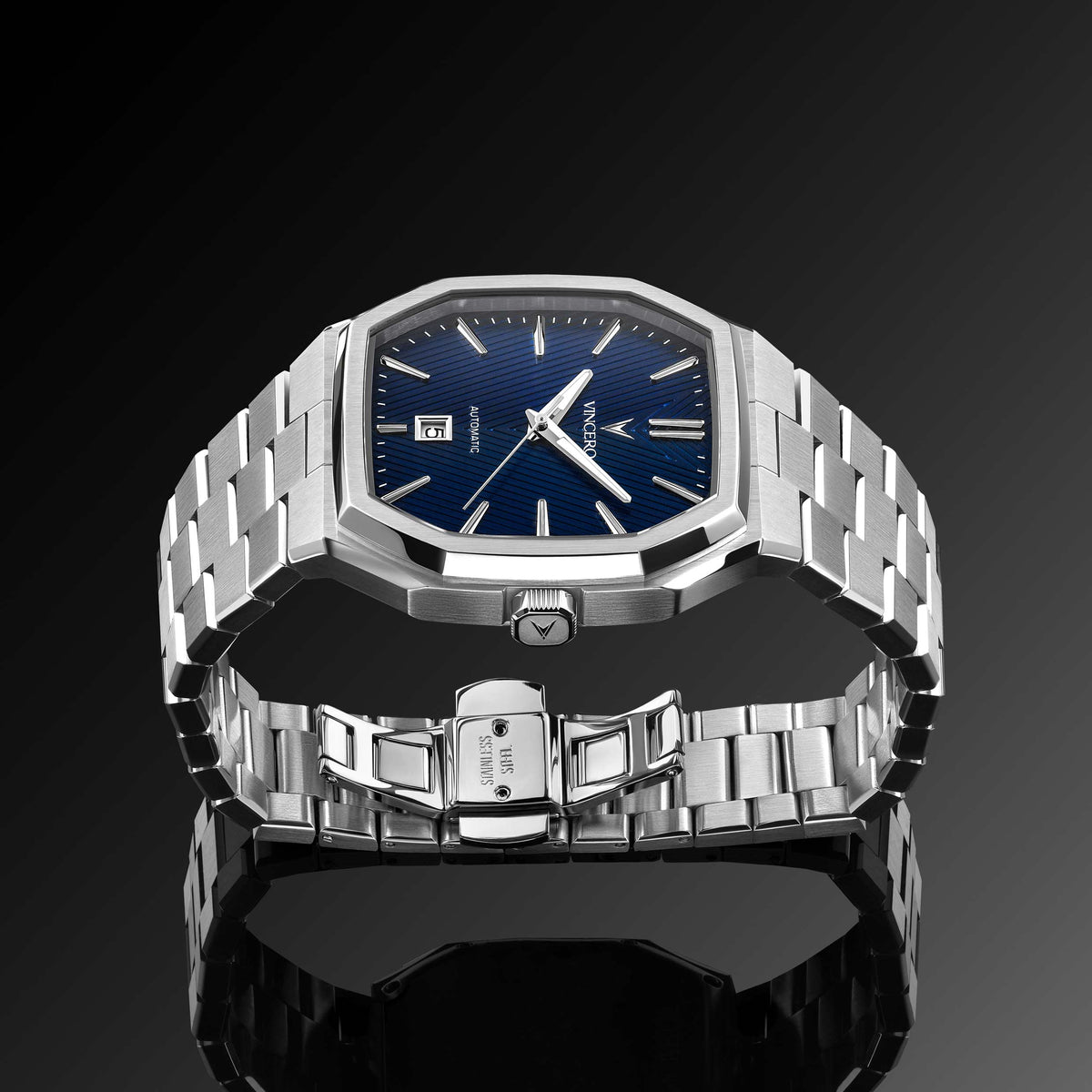 Silver watch with blue dial on a reflective black surface