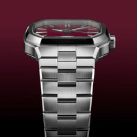 Silver watch with a red face on a dark red background