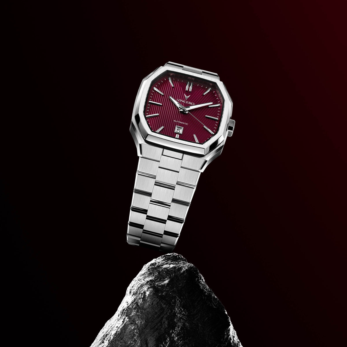 Silver watch with a red face on a black background