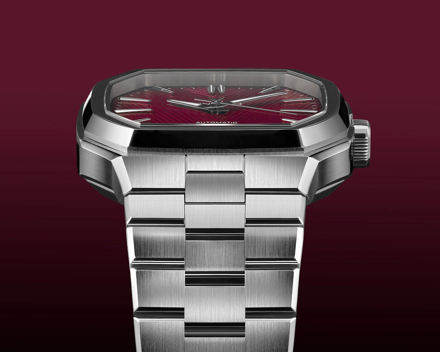 Silver watch with a red face on a dark red background