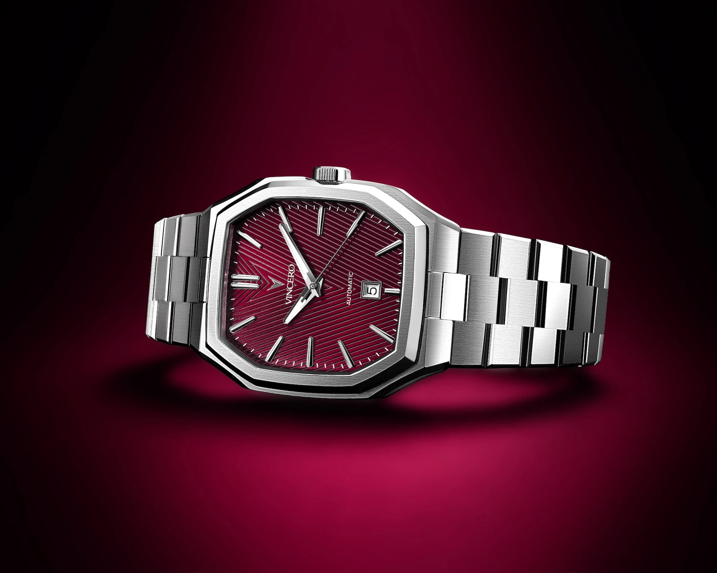 Silver watch with a red face on a dark red background