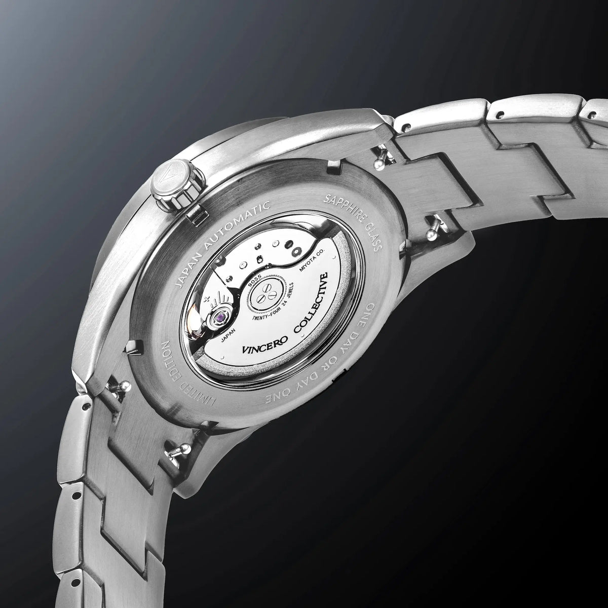 Close-up of a silver watch with visible brand name on a dark background