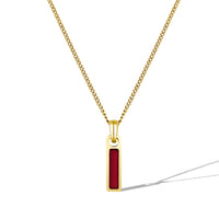 Gold necklace with a red pendant on a white background