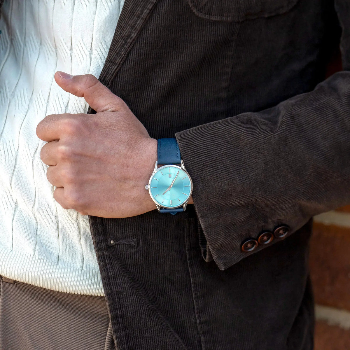 Person wearing a turquoise watch on a blurred background