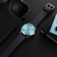 Wristwatch with blue face and black strap on a dark surface